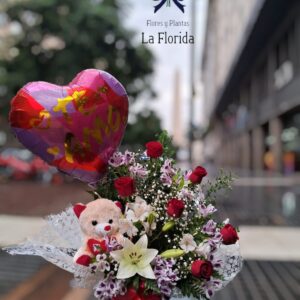 Arreglo con rosas importadas, liliums, globo, peluche en cesto de mimbre